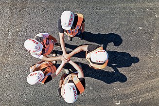 STRABAG-Bagger räumt Schlammmassen zwischen zwei Häusern. 