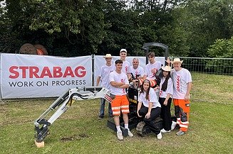 STRABAG-Bagger mit Helfern vor Ort um die Stände zu betreuen