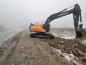 Bild mit einem Baggern und Kipplaster an der Reuss im Nebel