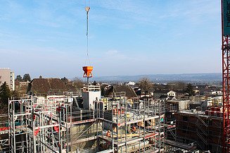 Betonkübel am Kranen mit Überblick über das Bauprojekt Hasenmatt