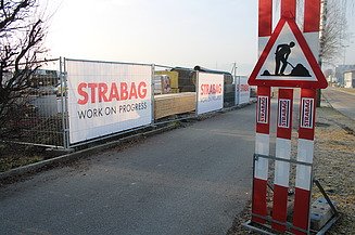 Warnschild Baustelle mit STRABAG Bauzäunen und Bauzaunbannern