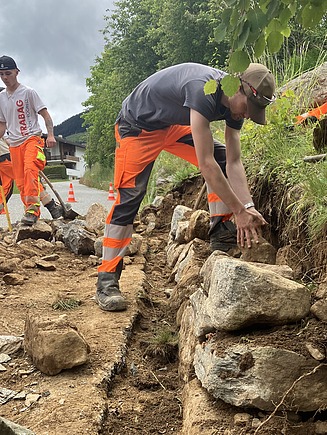 Lernende bei der Instand- und Versetzung einer Natursteinmauer