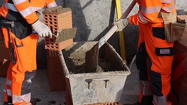 2 Mitarbeiter preparieren Beton fürs Mauern