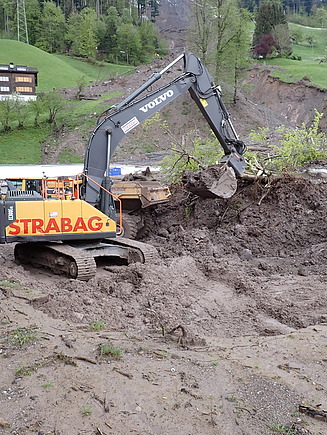 STRABAG-Bagger räumt Schlammmassen