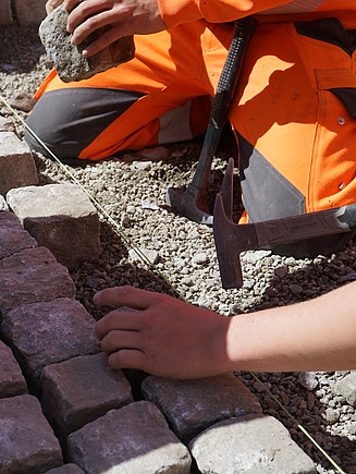 STRABAG-Lernende beim pflastern eines Vorplatzes