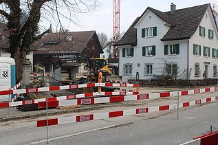 Grütstrasse mit Absperrlatten mit STRABAG Logo in weiss und rot