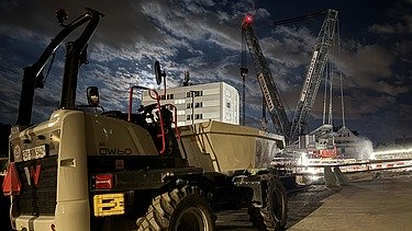 Aushub Schaffhauserstrassen Brücke Kloten Nachtarbeit - STRABAG Ingenieurbau STRABAG Dumper steht vor der Schaffhauserstrassen Brücke im Hintergrund der 750 Tonnen Raupenkran